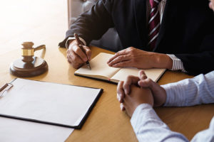 lawyer and client sitting at desk with papers